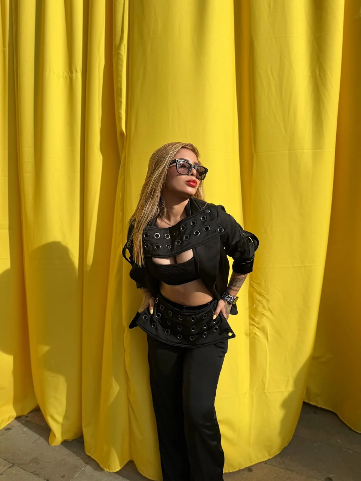 Presentación del conjunto negro de Louva ante un fondo amarillo