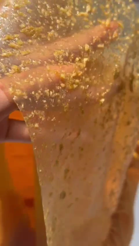 Muestra de material ámbar sostenida por su borde