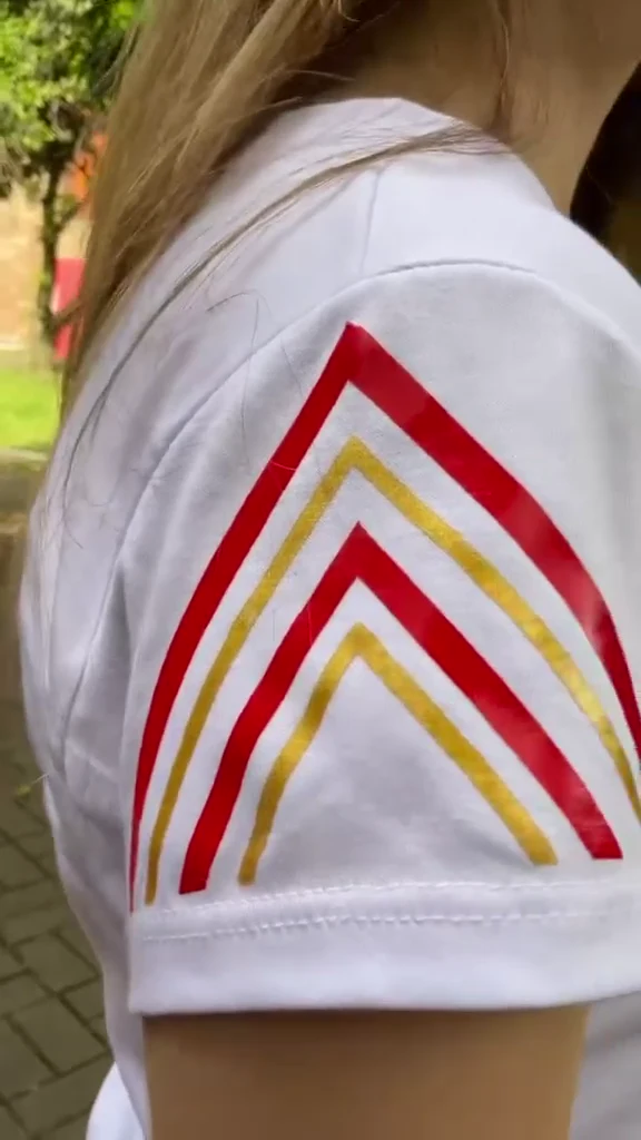 Detalle rojo y amarillo en la manga de la camiseta blanca